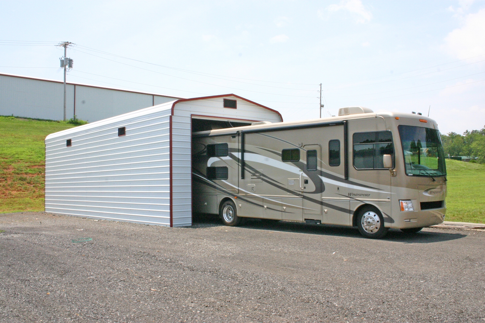 rv-metal-garage RV metal garage with white sides and ends, and red trim.