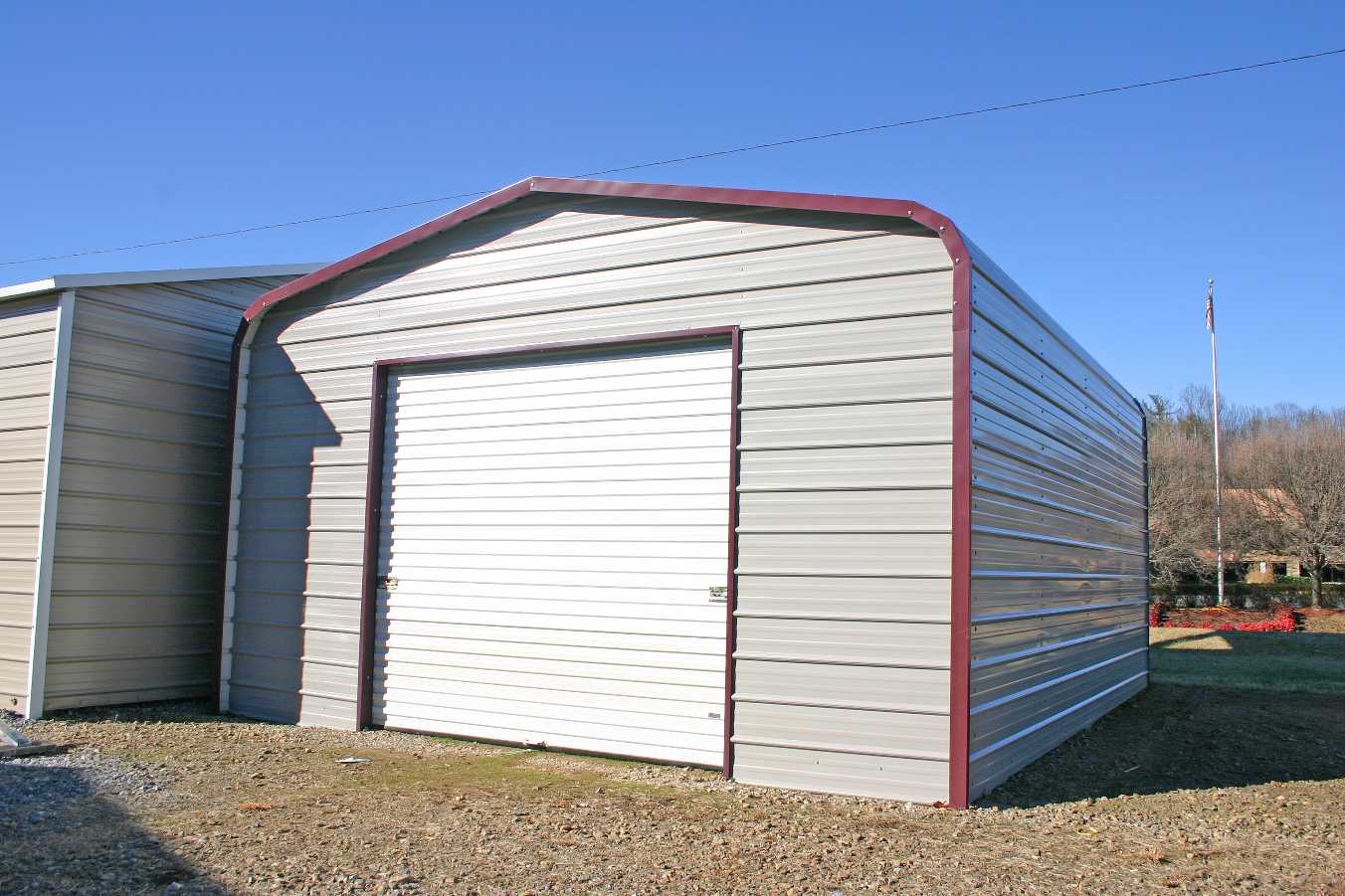 standard-metal-garage Standard metal garage with white roll up garage door and red trim.
